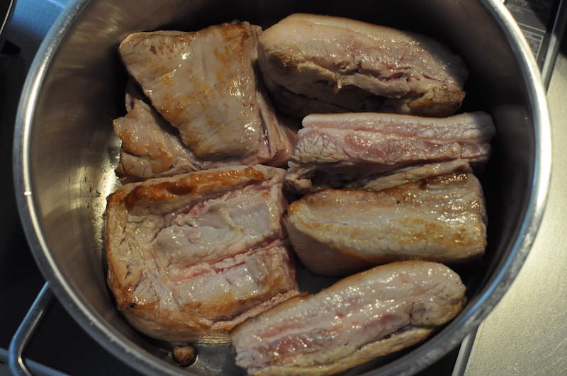 豚ばら肉を炒めて鍋に敷き詰めます